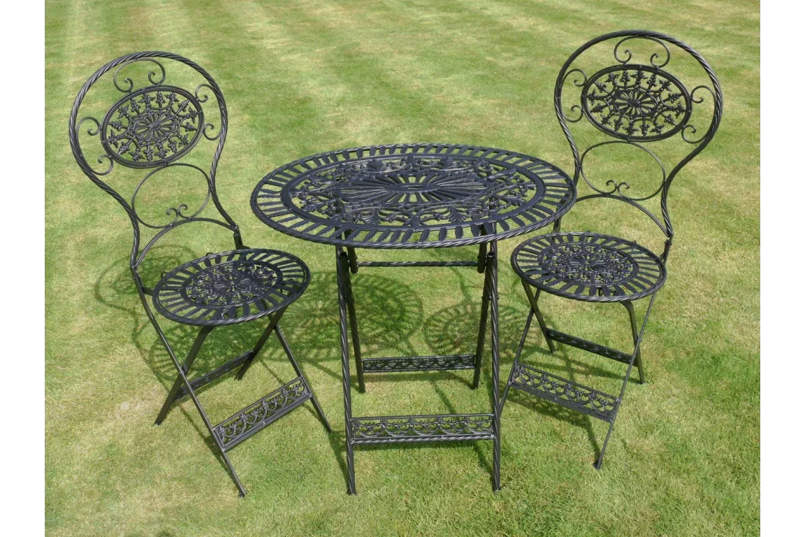 Black metal garden bistro set with two chairs and round table on grass