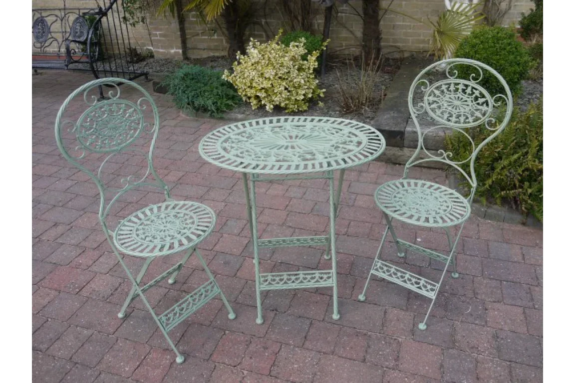 Green metal garden bistro set with round table and two chairs on patio