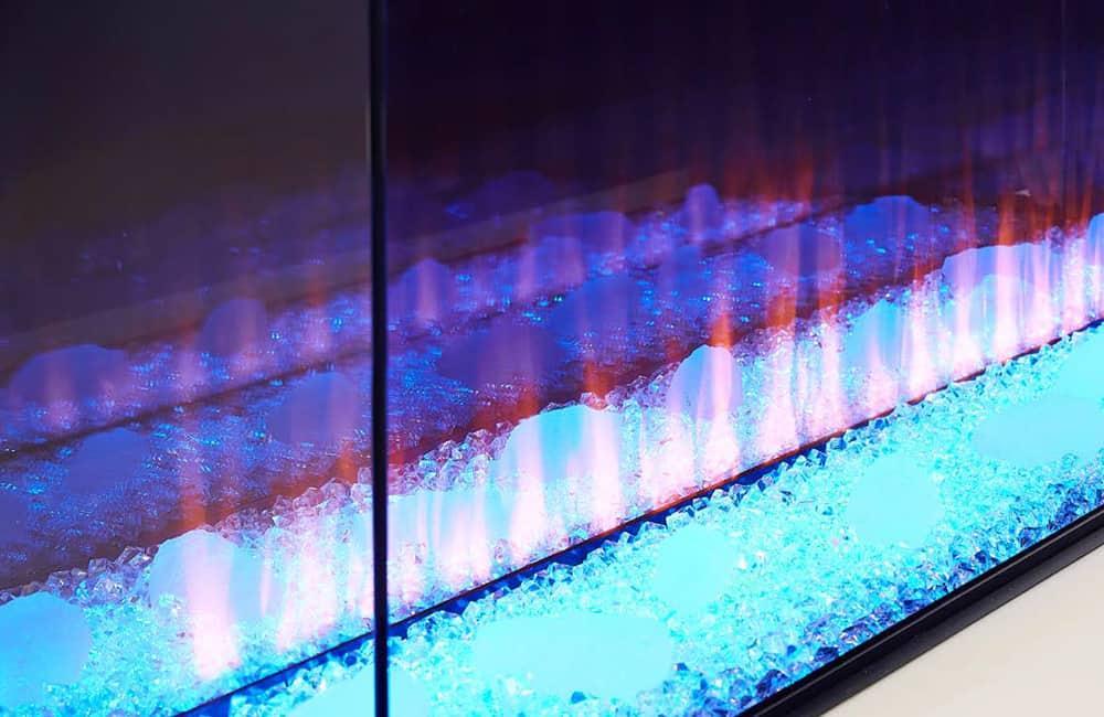 Electric fireplace closeup with blue LED lighting and clear crystal gravel