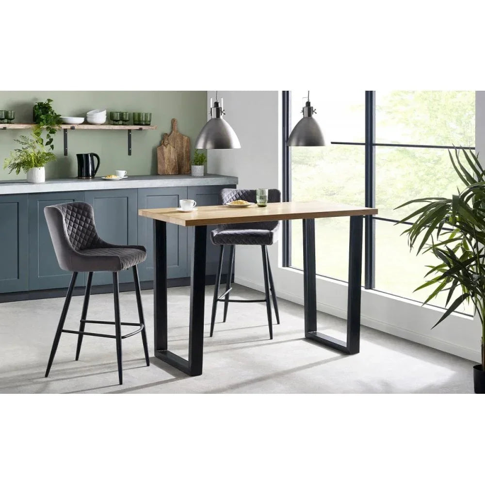 Modern kitchen with wooden bar table, black metal legs, and two grey fabric bar stools