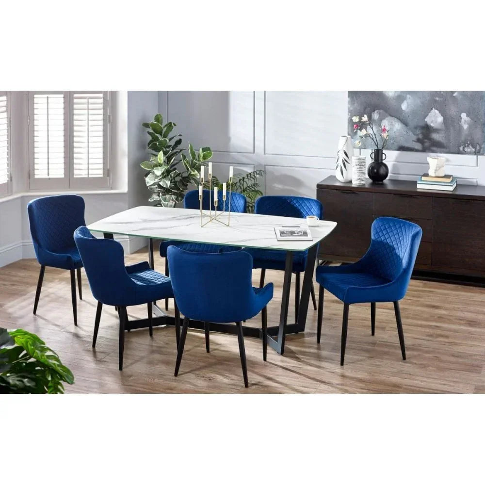 Marble top dining table with six blue upholstered chairs in modern dining room