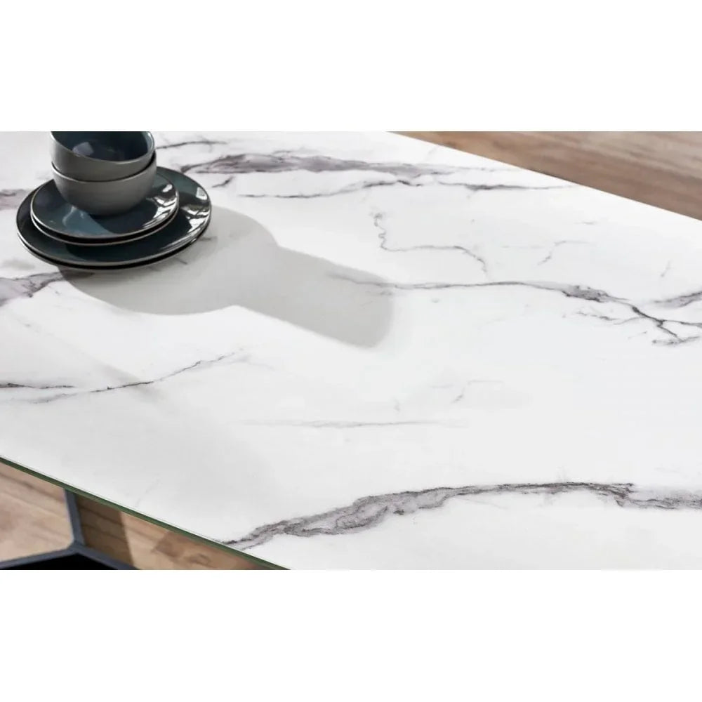 White marble dining table top with grey veins and stacked dark ceramic dishes