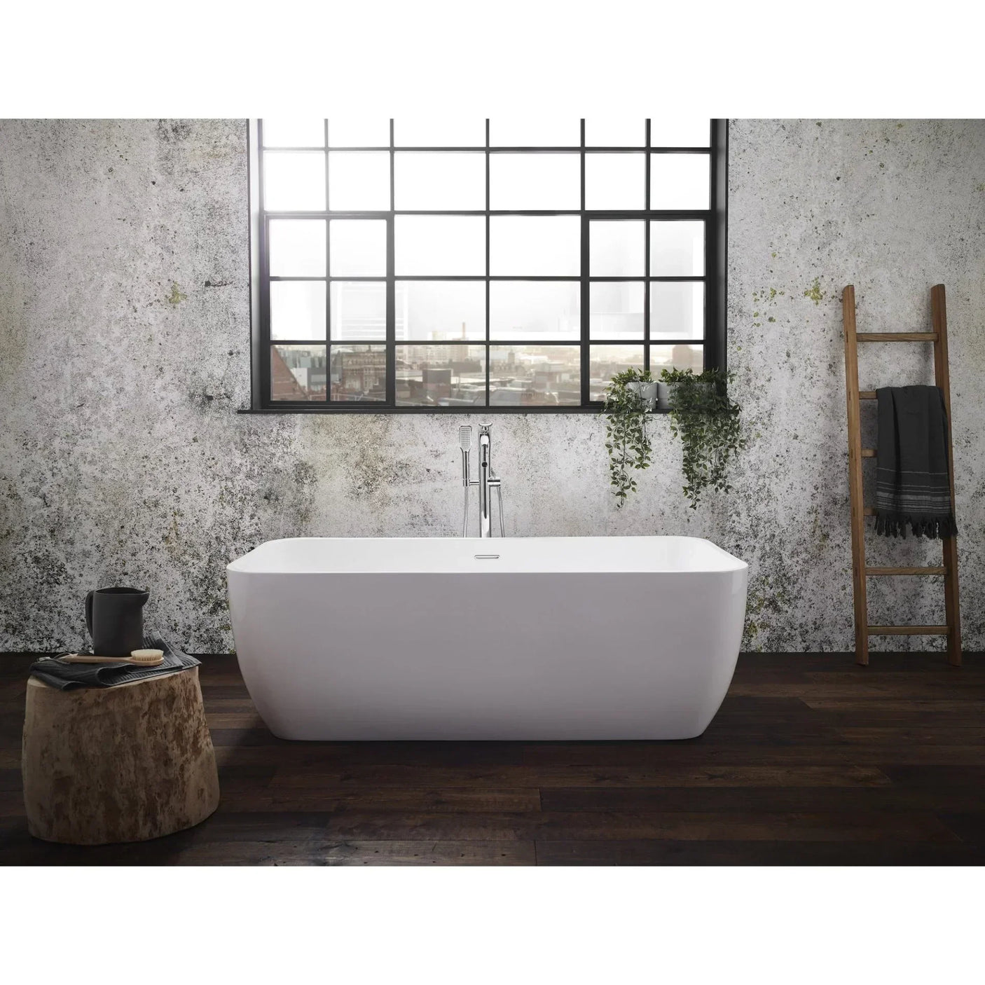 Modern freestanding white bathtub with floor tap in industrial style bathroom with large window