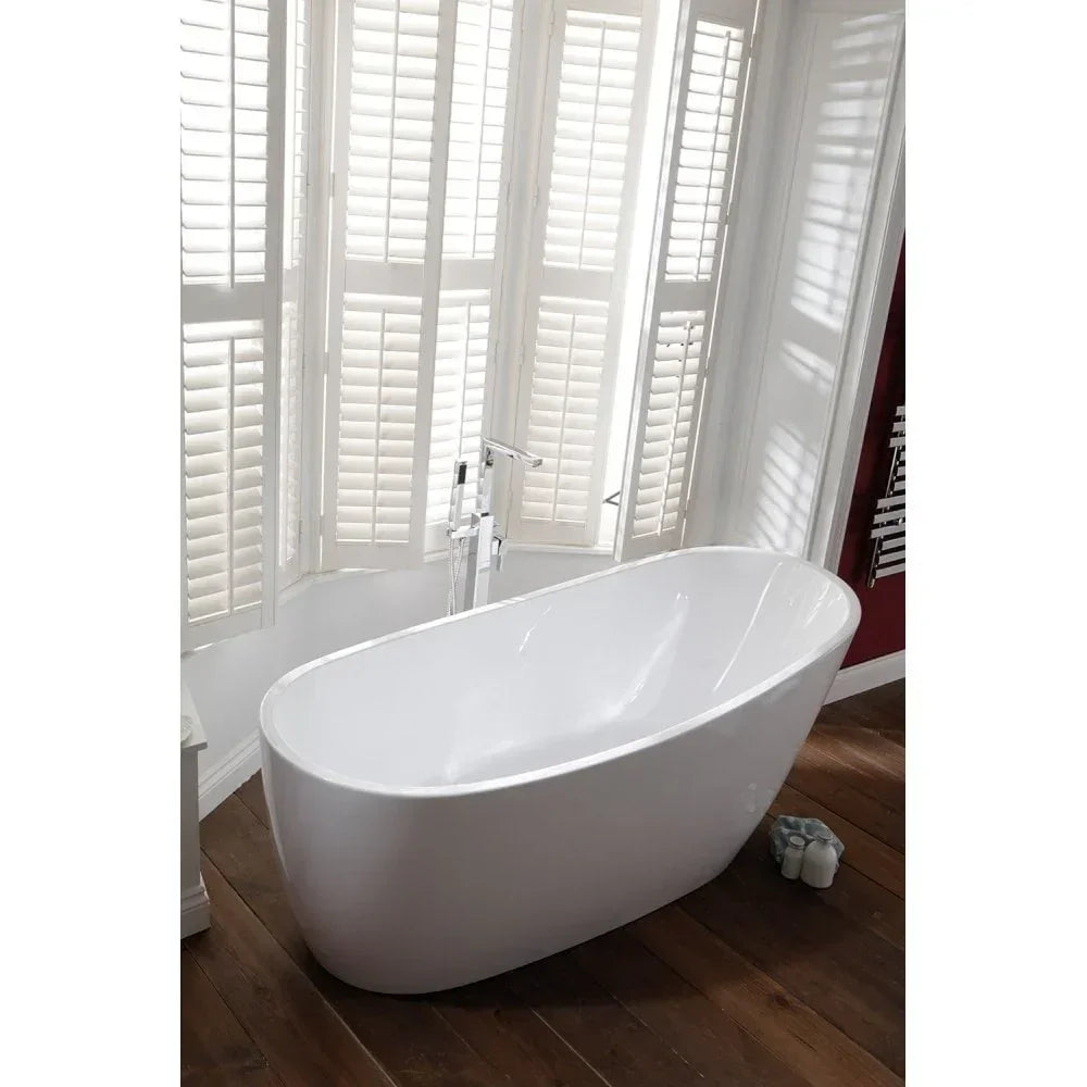 Freestanding white bath on wooden floor beside bay window with plantation shutters