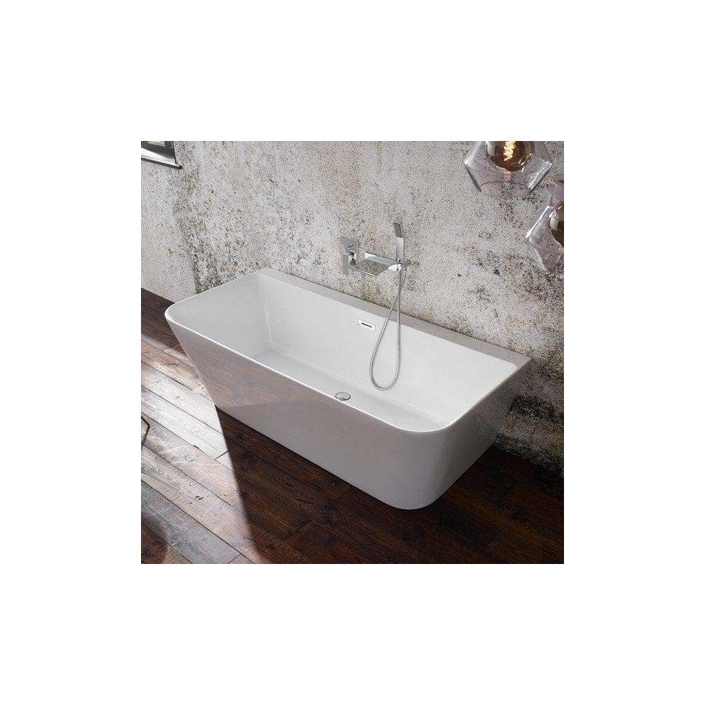 Modern freestanding white bathtub with chrome tap set on dark wood bathroom floor