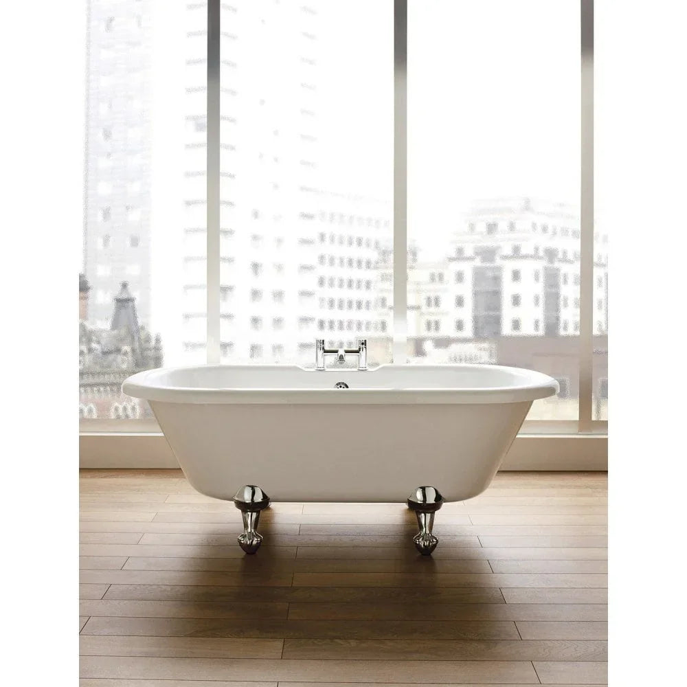 freestanding bath with chrome claw feet on wooden floor beside large city view windows