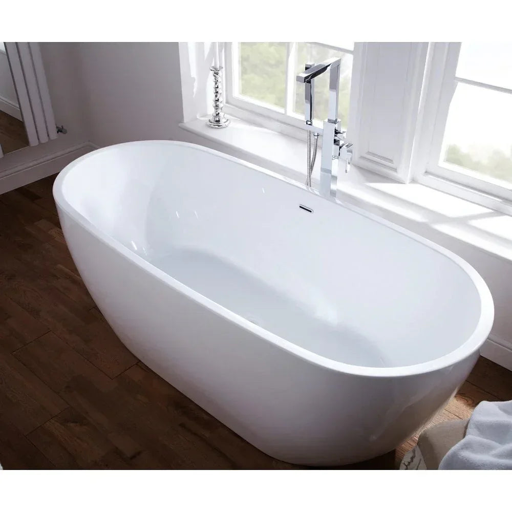 White freestanding bath with chrome mixer tap beside window on wood floor