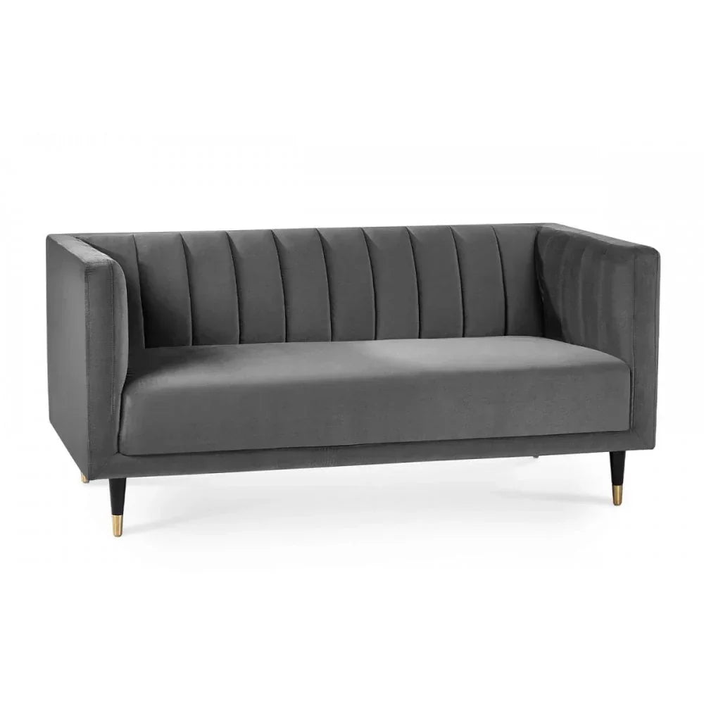 Grey velvet sofa with channel tufted back and arms, black tapered legs with gold tips