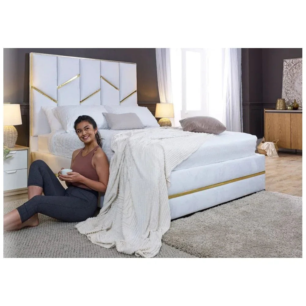 White upholstered bed with geometric gold headboard, bedside tables and lamps in modern bedroom