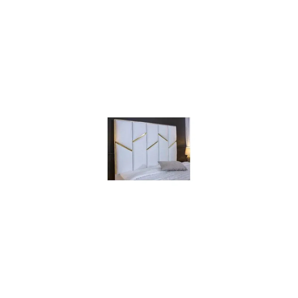 White upholstered headboard with gold accent panels behind bed in modern bedroom
