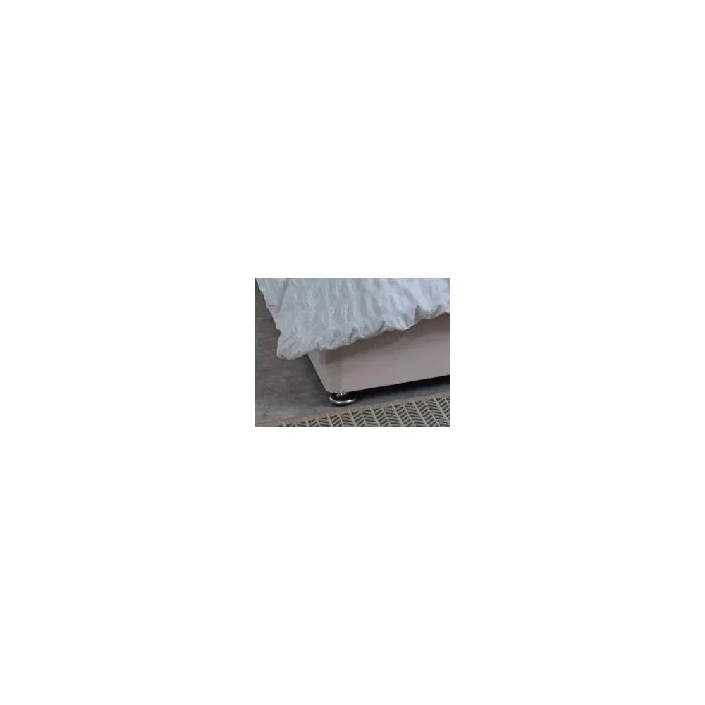 Fabric bed base with chrome feet and textured white bedding in a modern bedroom setting