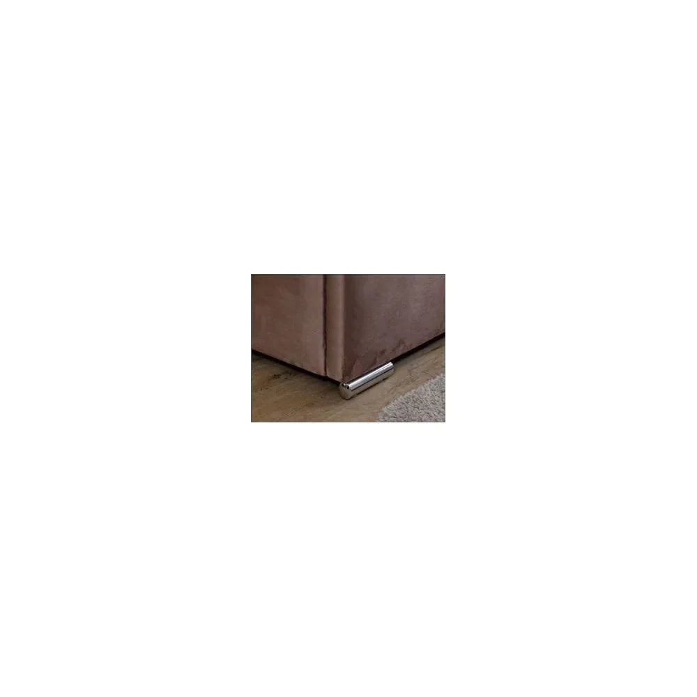 Close-up of sofa corner with chrome metal leg on wooden floor beside rug