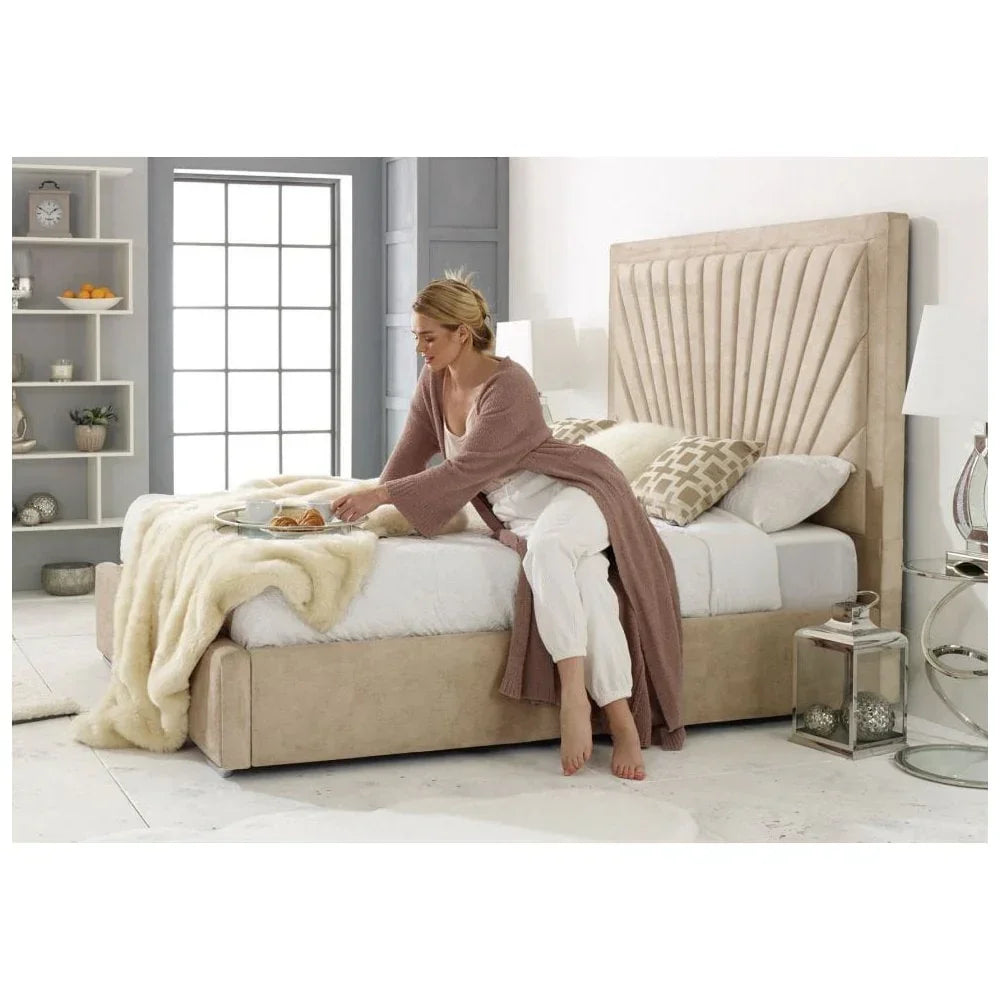 Beige upholstered bed with tall headboard and throw blanket in bright modern bedroom