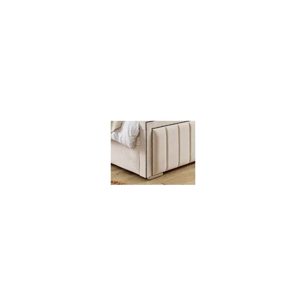 Beige upholstered bed frame with vertical stitched panel detail on wooden floor