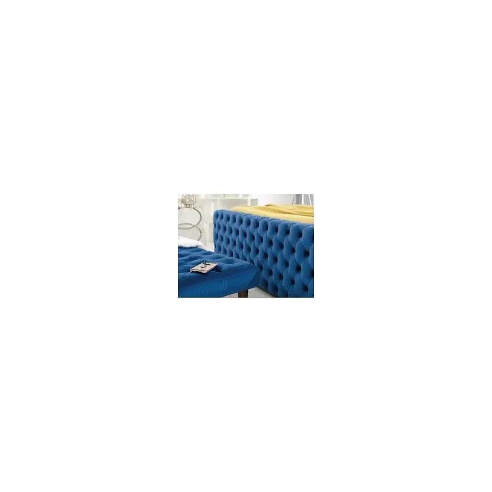 Blue upholstered bed frame with deep button tufting and matching bench in modern bedroom