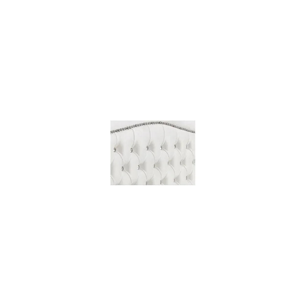 White upholstered bed headboard with diamond button tufting and silver trim closeup