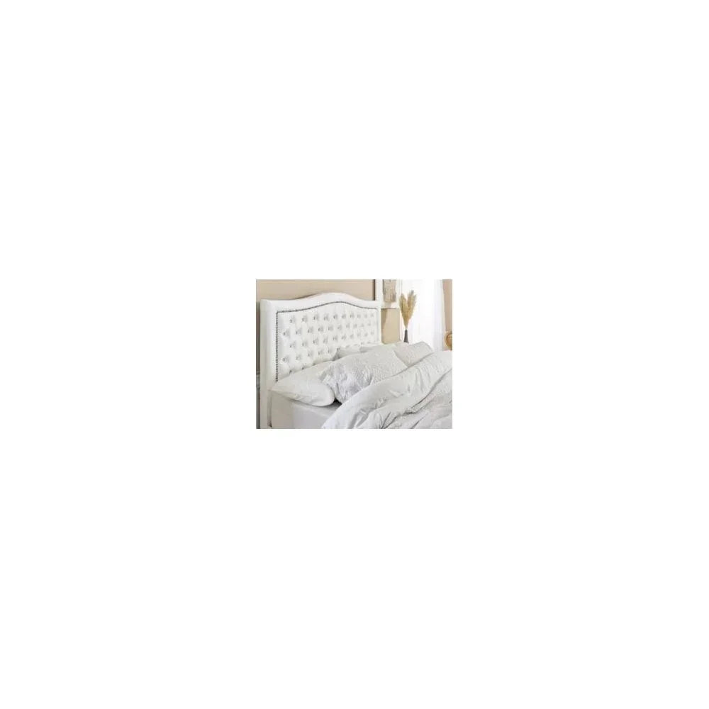 White upholstered bed with button tufted headboard in a modern bedroom