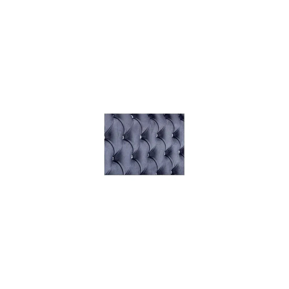 Closeup of grey velvet upholstered bed headboard with diamond tufting