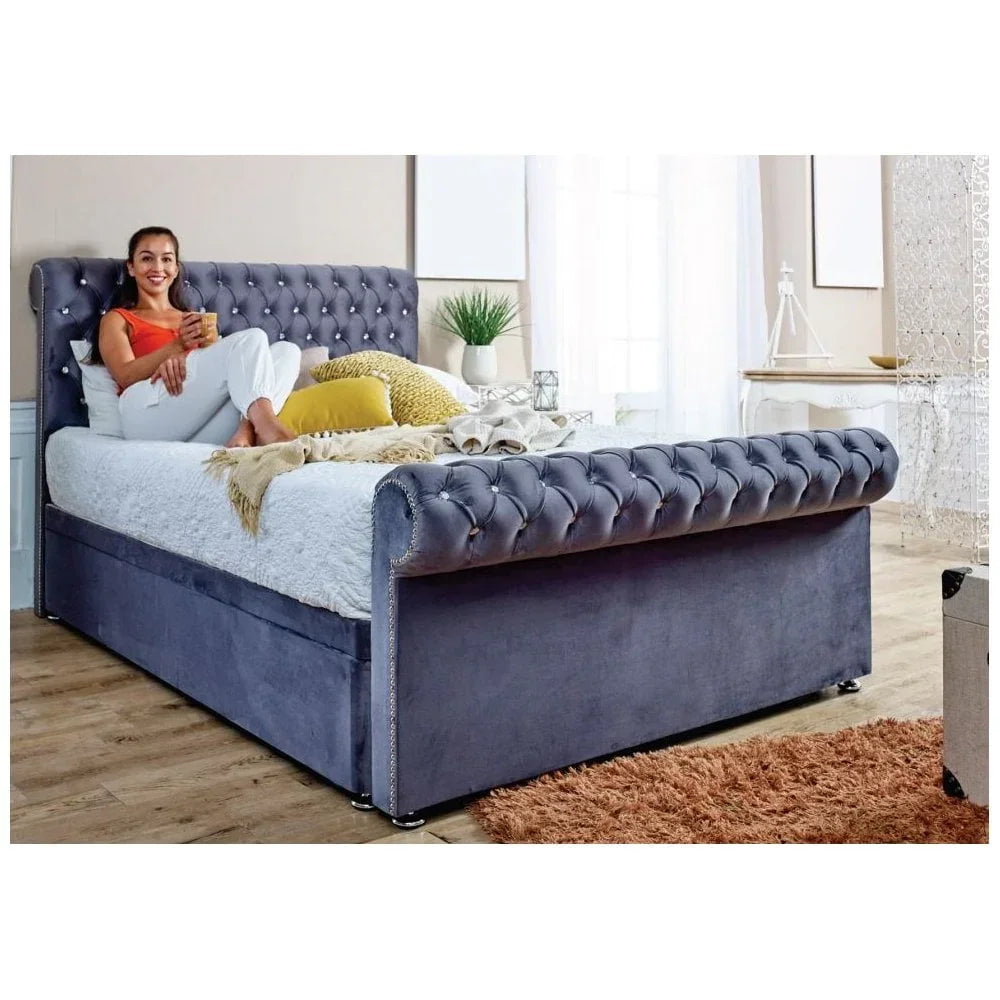 Grey velvet upholstered bed with button-tufted headboard and footboard in bedroom setting
