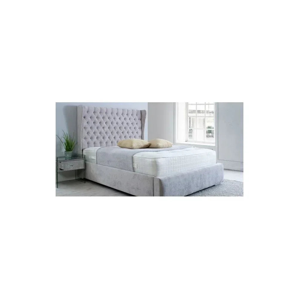 Grey upholstered bed frame with tall button-tufted headboard and mattress in modern bedroom