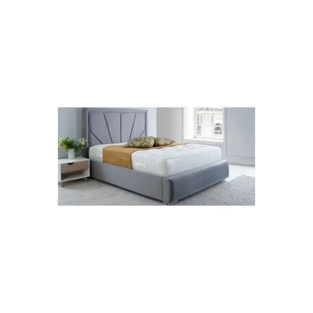 Grey upholstered bed frame with mattress in modern bedroom next to white nightstand