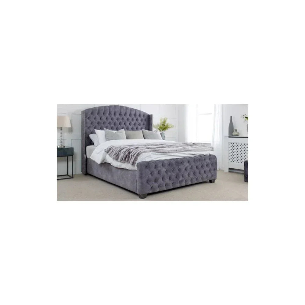 Grey upholstered bed with tufted headboard and footboard in modern bedroom setting
