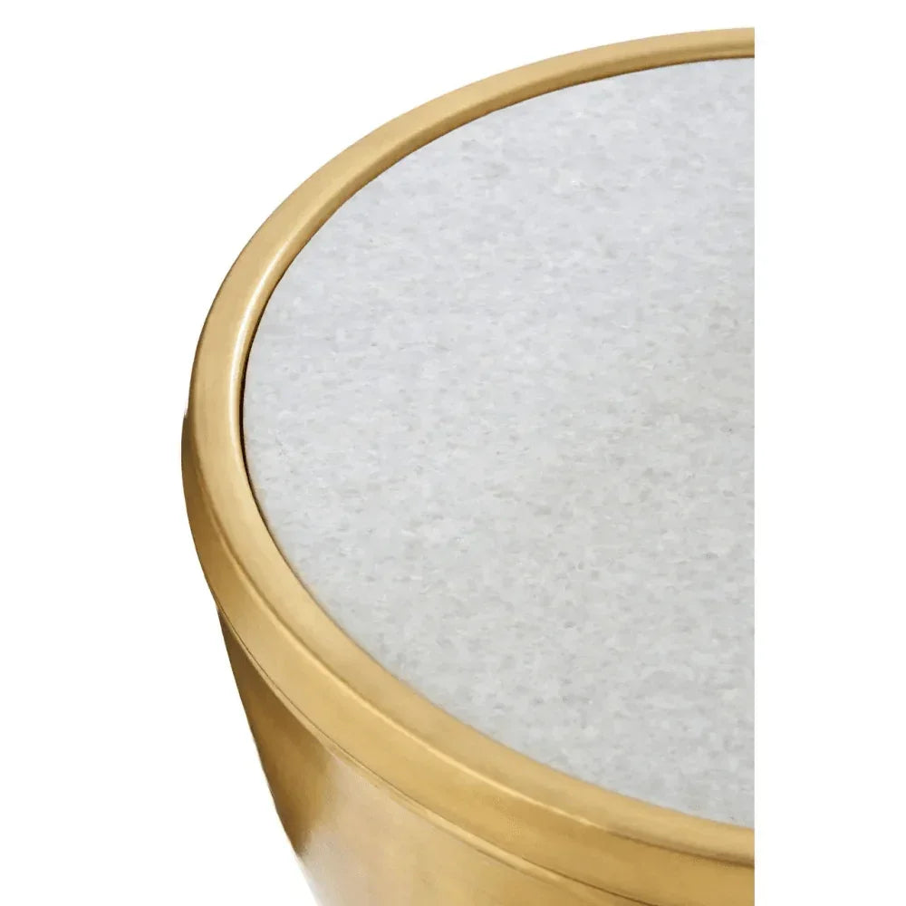 Round side table with gold metal frame and white marble top, closeup of tabletop edge