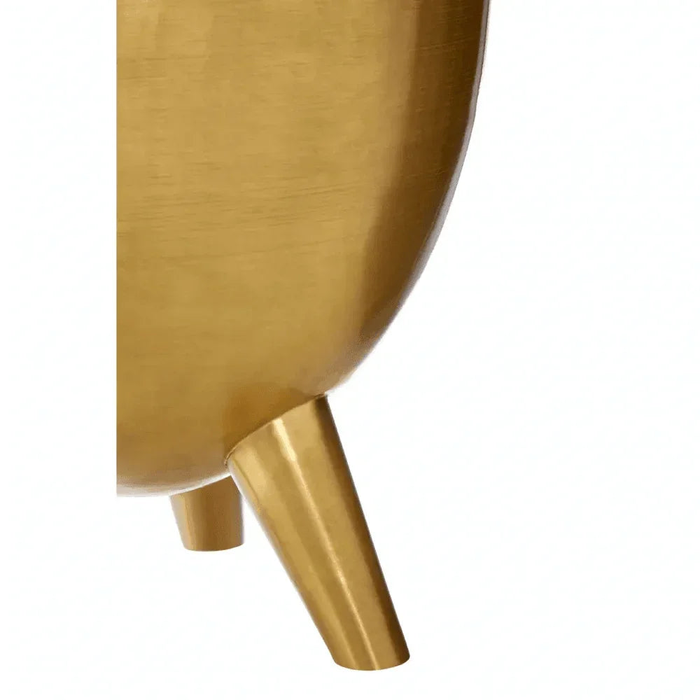 Gold metal planter close-up showing round base and angled legs