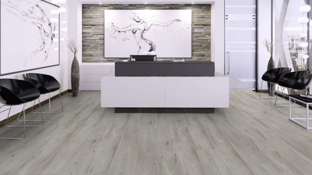 Light oak effect laminate flooring in a modern reception area with black chairs and artwork