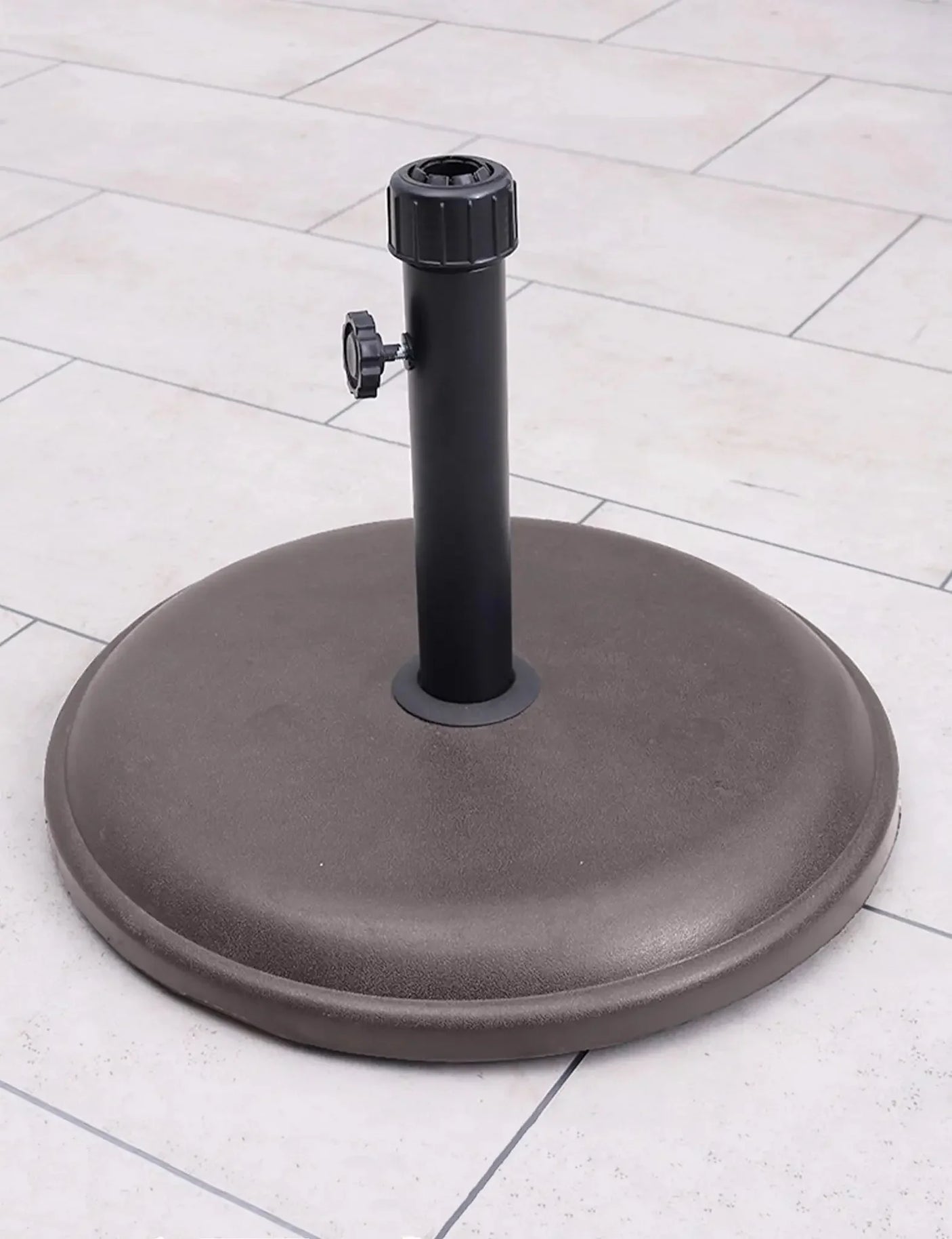 16kg brown round parasol base with polycrete finish on outdoor patio tiles