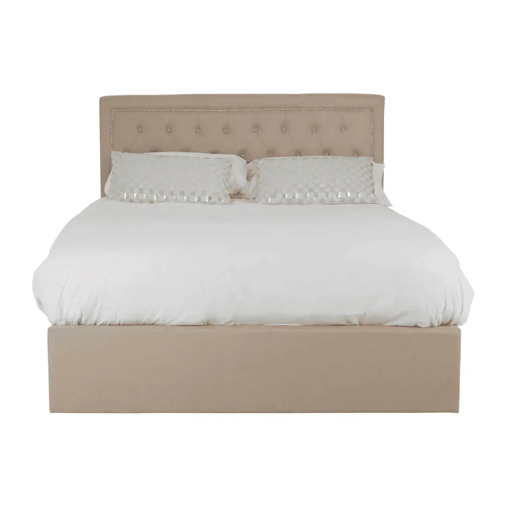 Beige upholstered bed frame with button-tufted headboard and white bedding