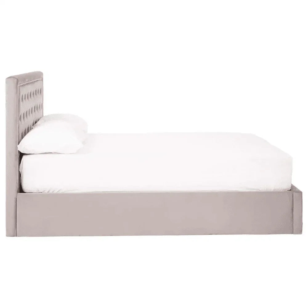 Side view of grey upholstered bed frame with tufted headboard and white bedding
