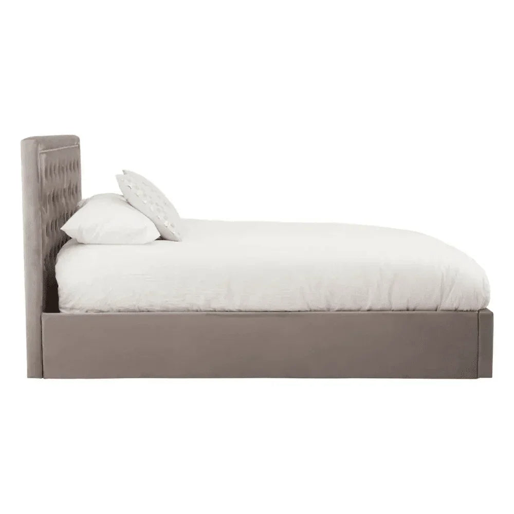 Side view of upholstered bed frame with tufted headboard and white bedding