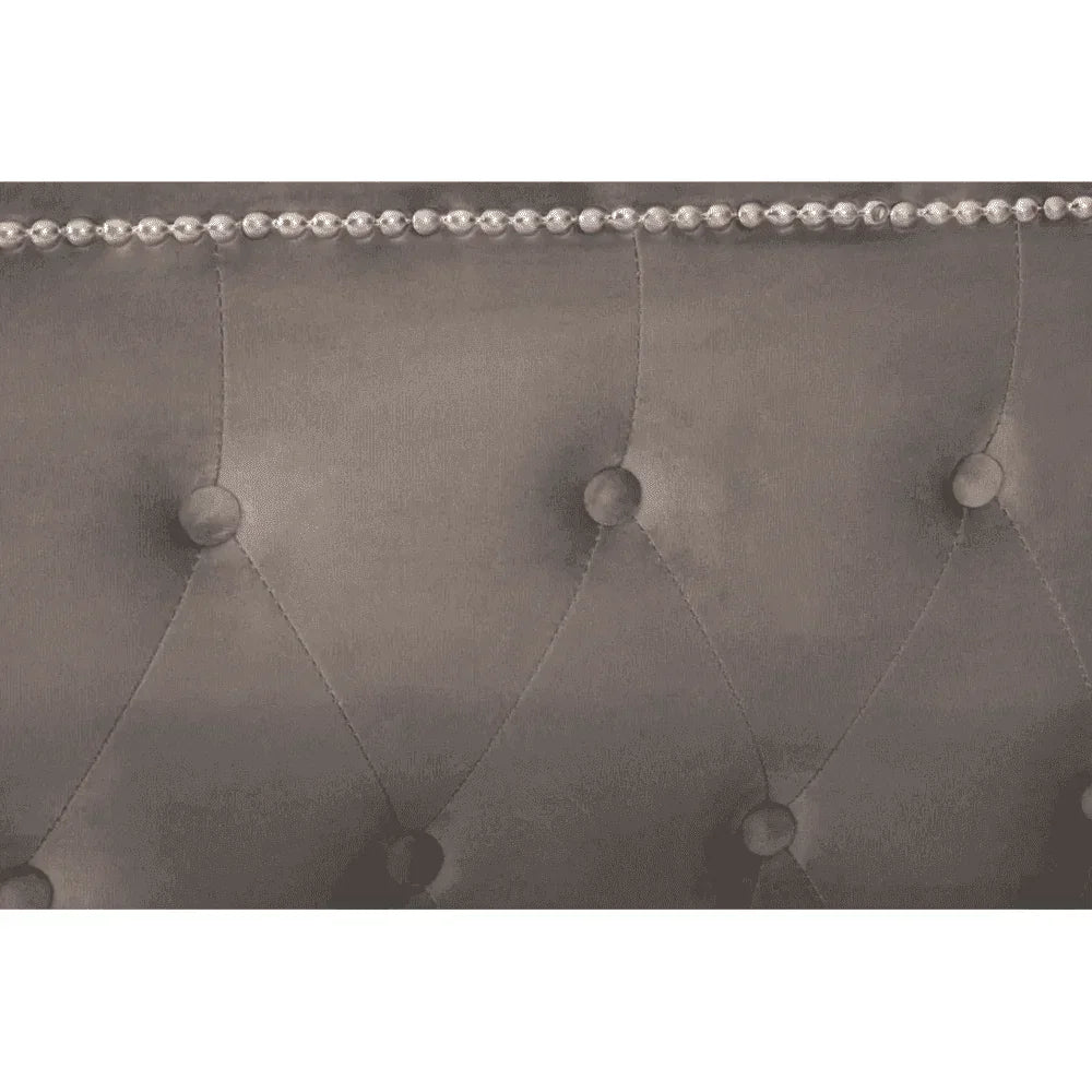 Grey upholstered bed headboard with diamond button tufting and silver stud detailing