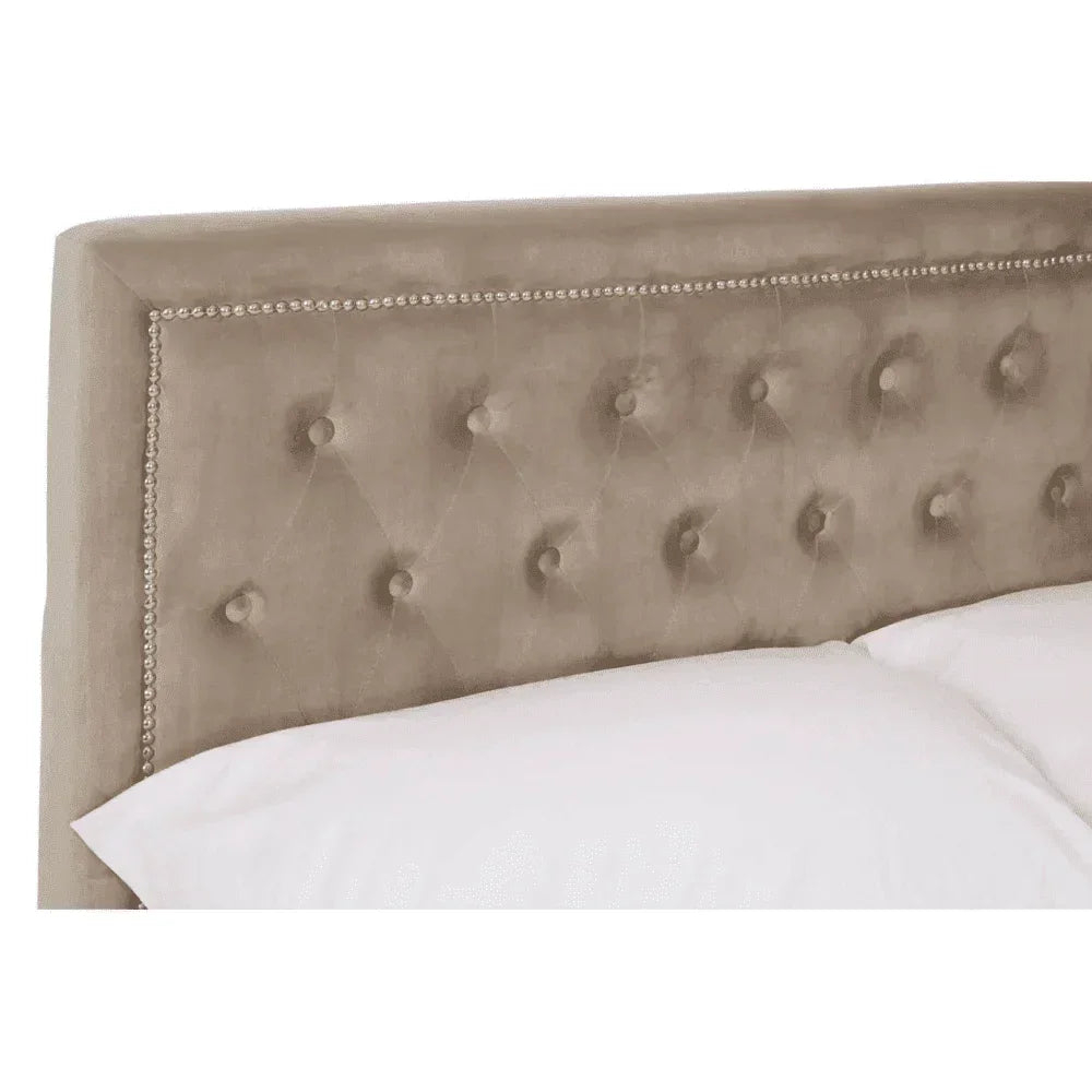 Beige upholstered bed headboard with button tufting and metallic stud trim