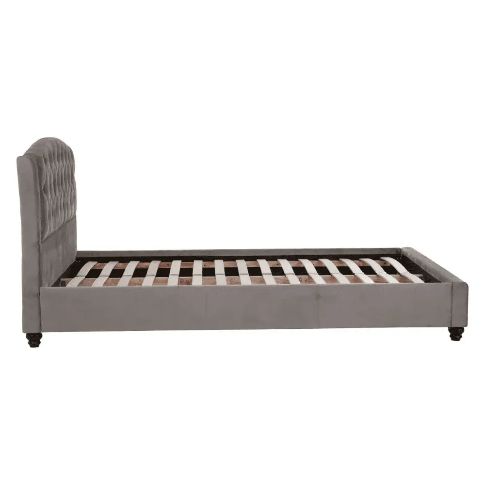Grey upholstered bed frame with slatted base and tufted headboard, side view