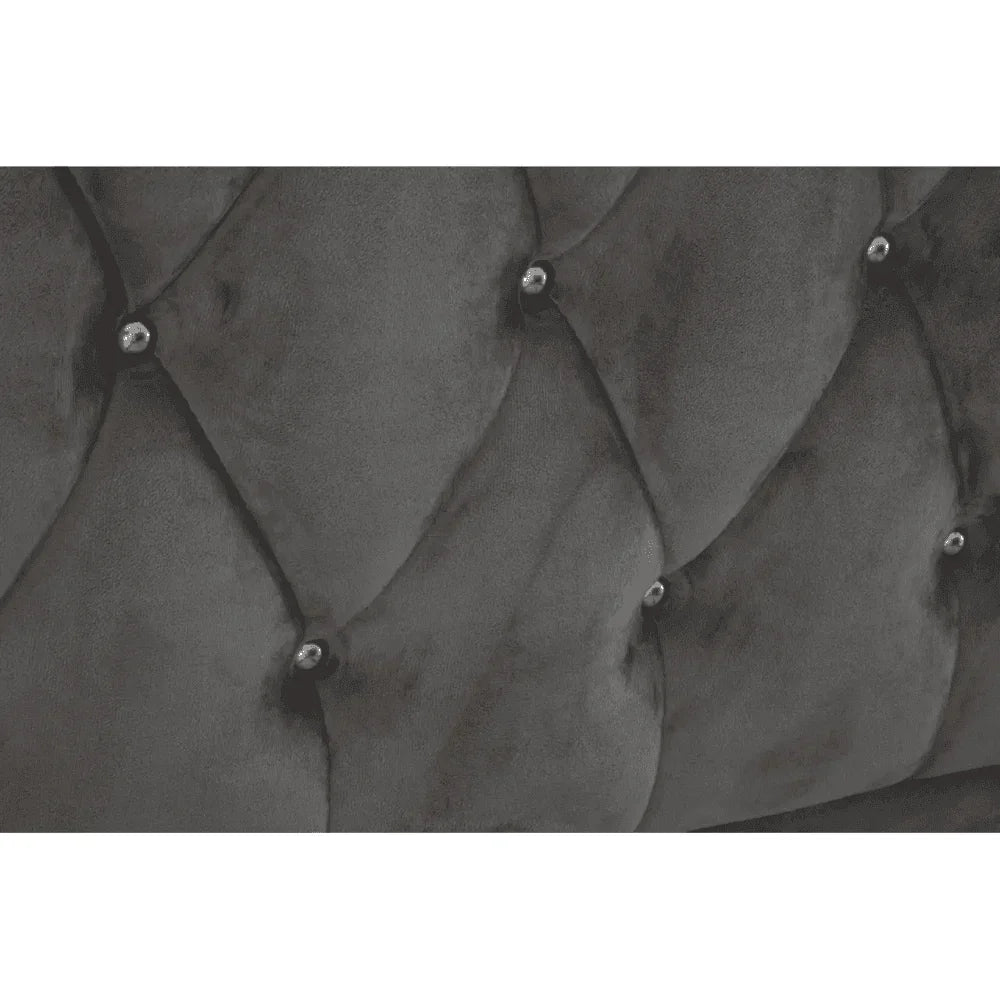 Close view of dark grey velvet bed headboard with diamond button tufting
