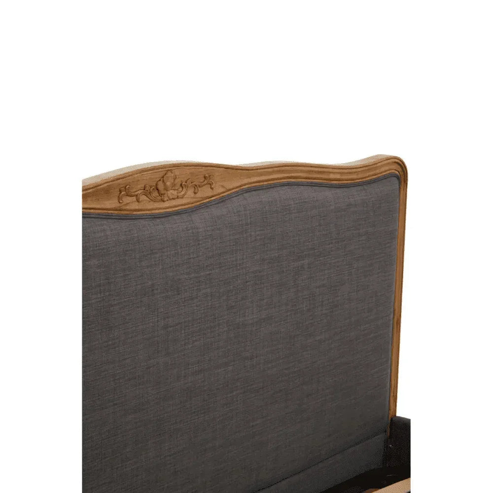 Upholstered bed headboard with grey fabric and carved wood trim detail