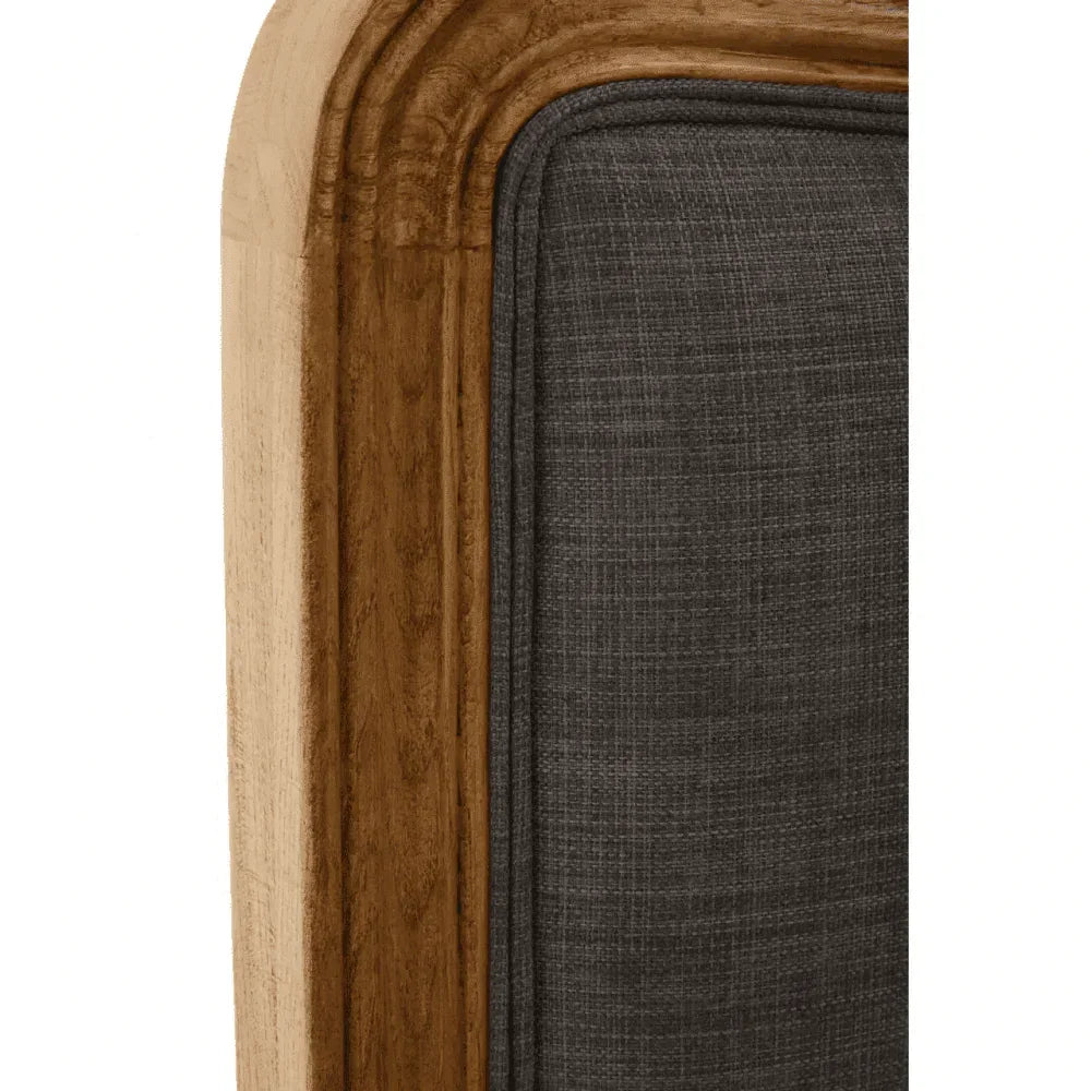 Closeup of wooden bed frame with grey fabric upholstery detail