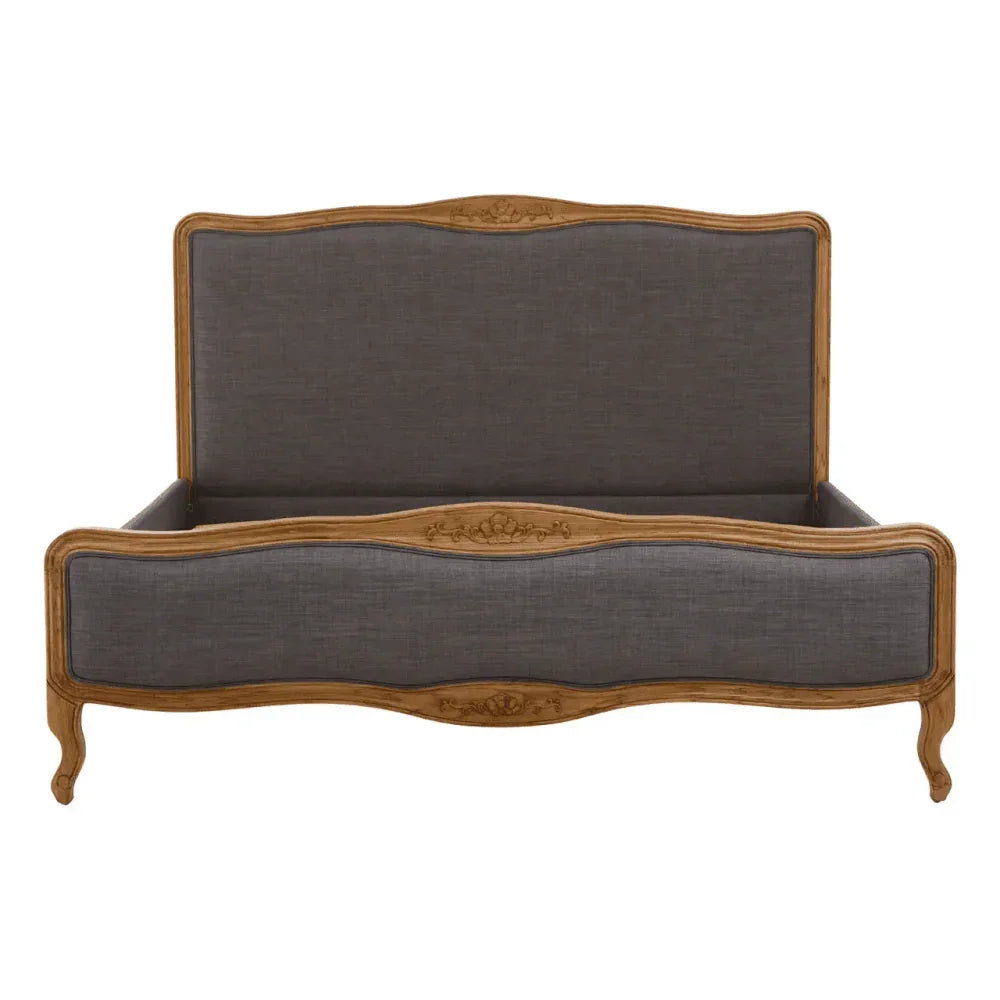 Grey upholstered wooden bed frame with carved detailing and curved legs, front view