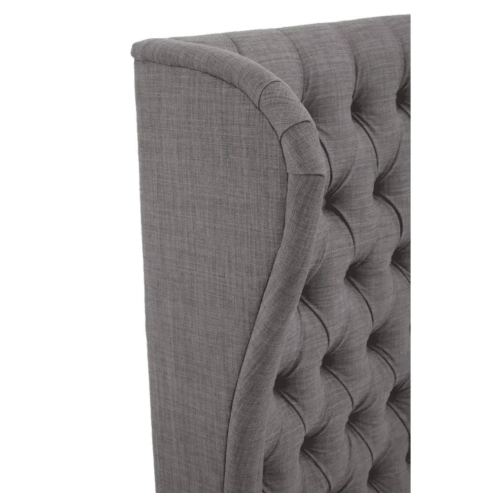 Upholstered fabric headboard in grey with button tufted detail, close side angle view