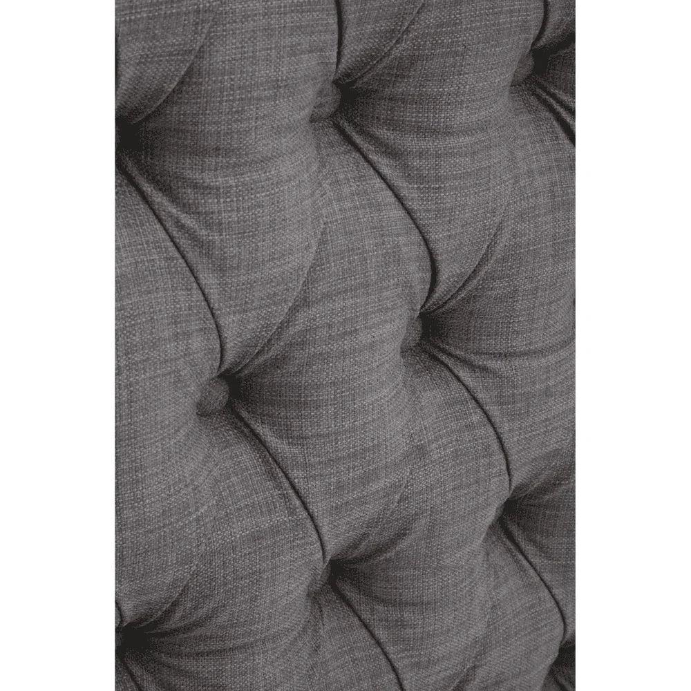 Closeup of grey fabric sofa with deep button tufting and textured upholstery