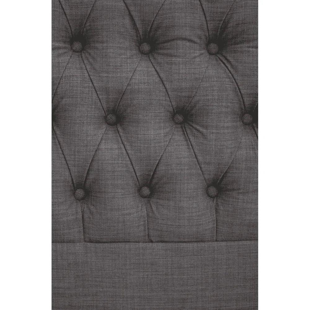 Grey button-tufted fabric headboard detail, close-up of upholstery texture