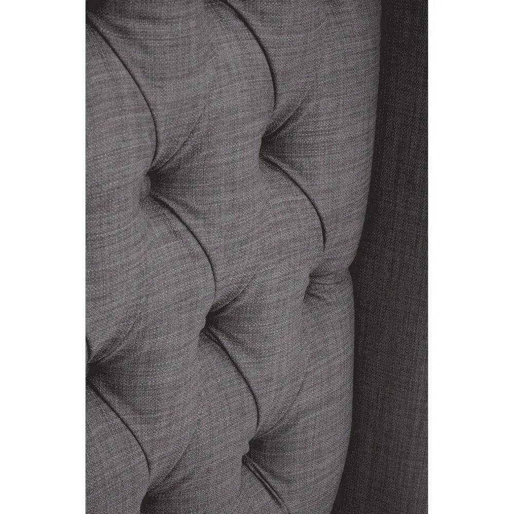 Close-up of grey fabric sofa with deep button tufted upholstery