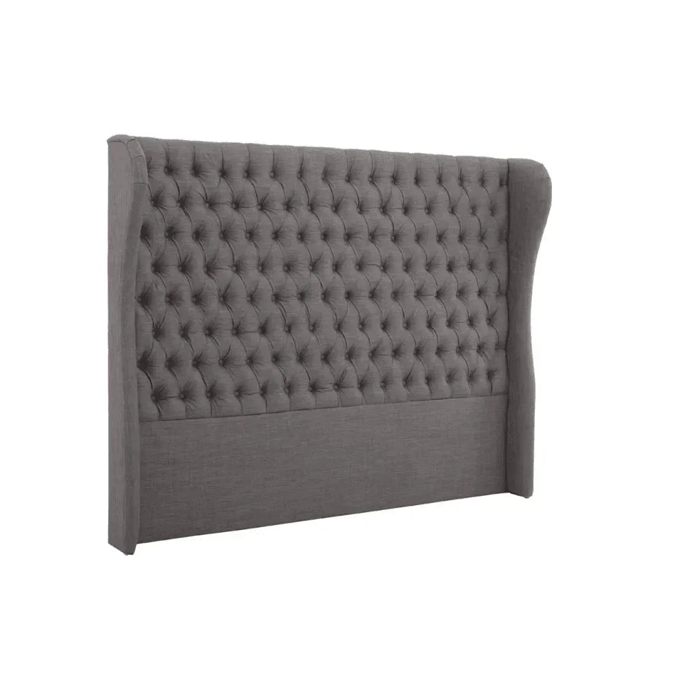 Grey upholstered wingback headboard with deep button tufting, side angle view