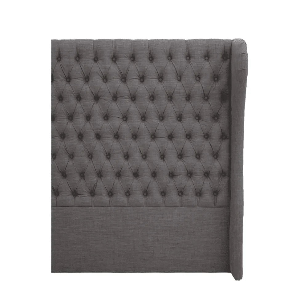 Dark grey upholstered headboard with deep button tufting and winged side profile
