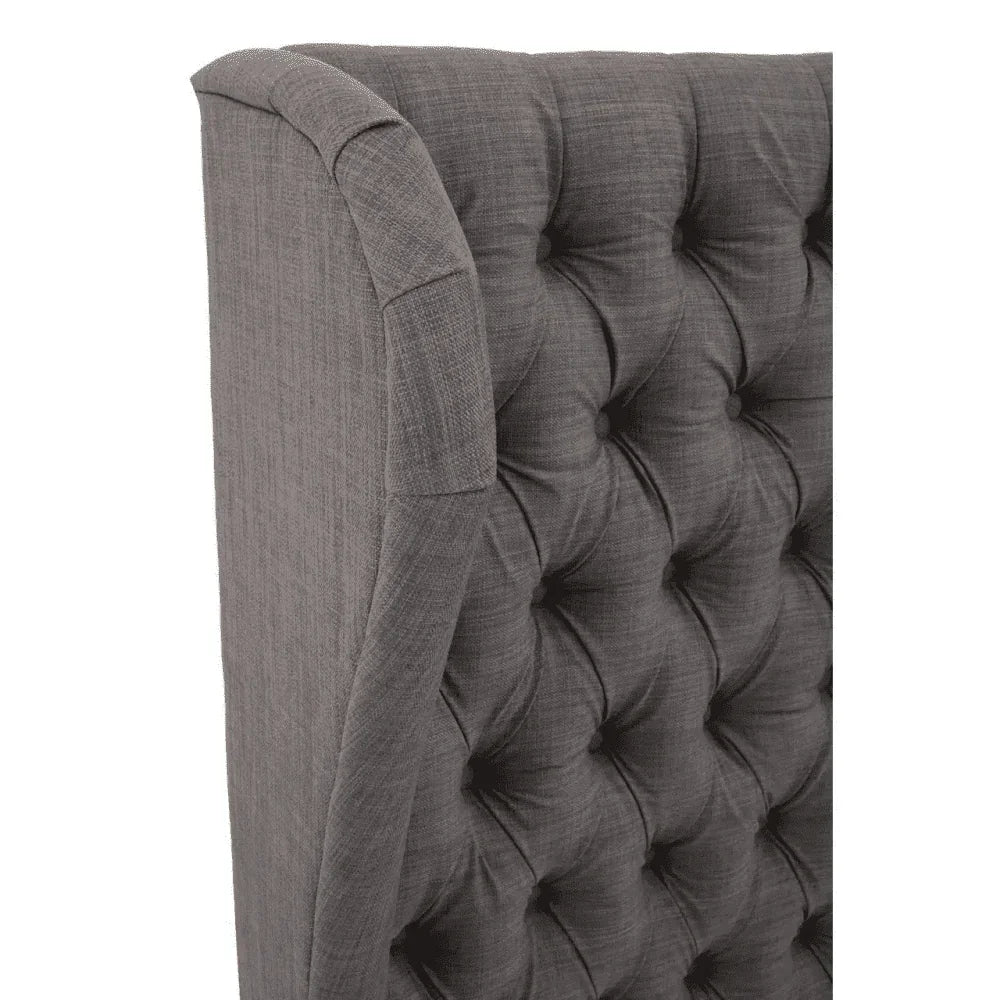Grey upholstered bed headboard with deep button tufting, side angle view