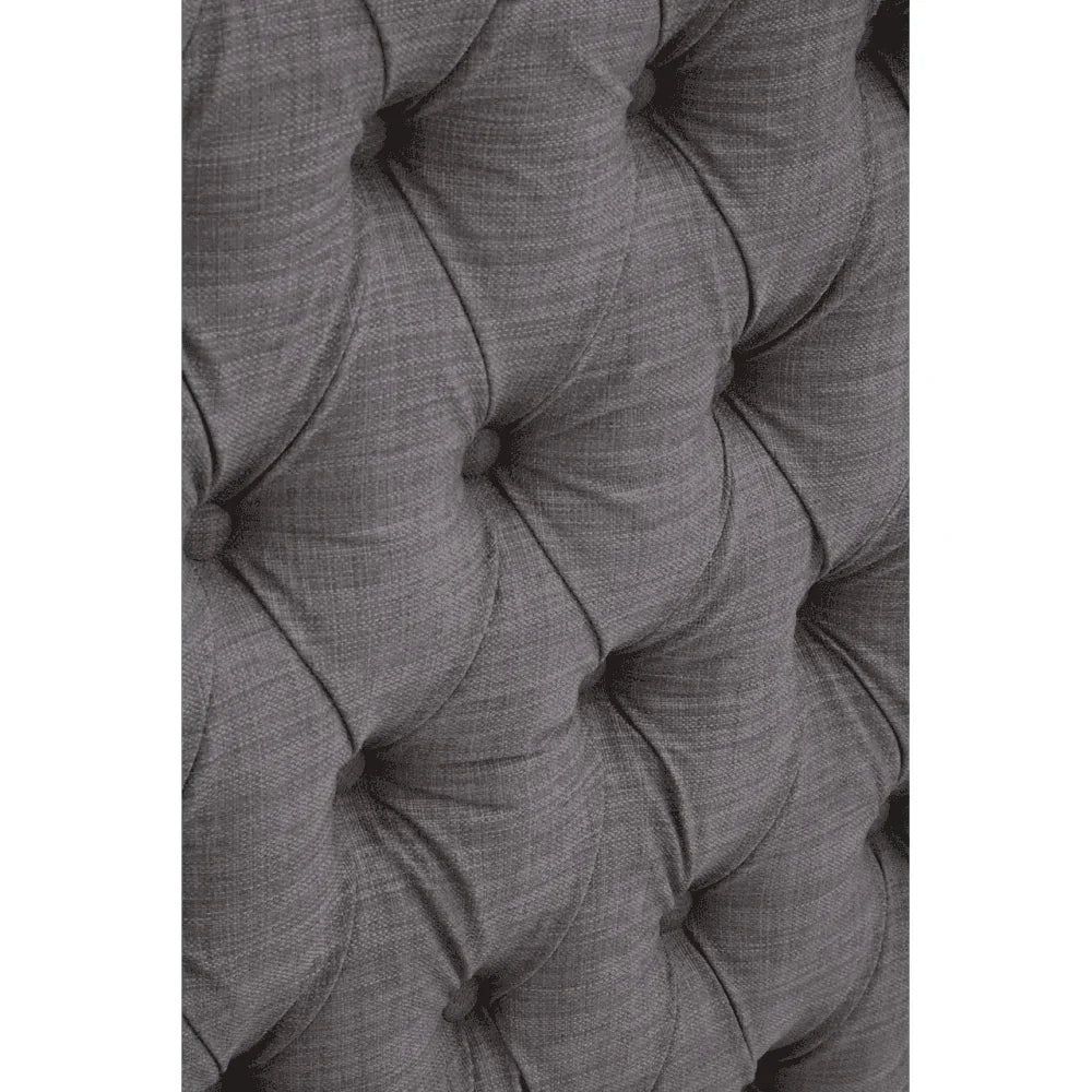 Closeup of tufted grey fabric sofa upholstery with deep button detail