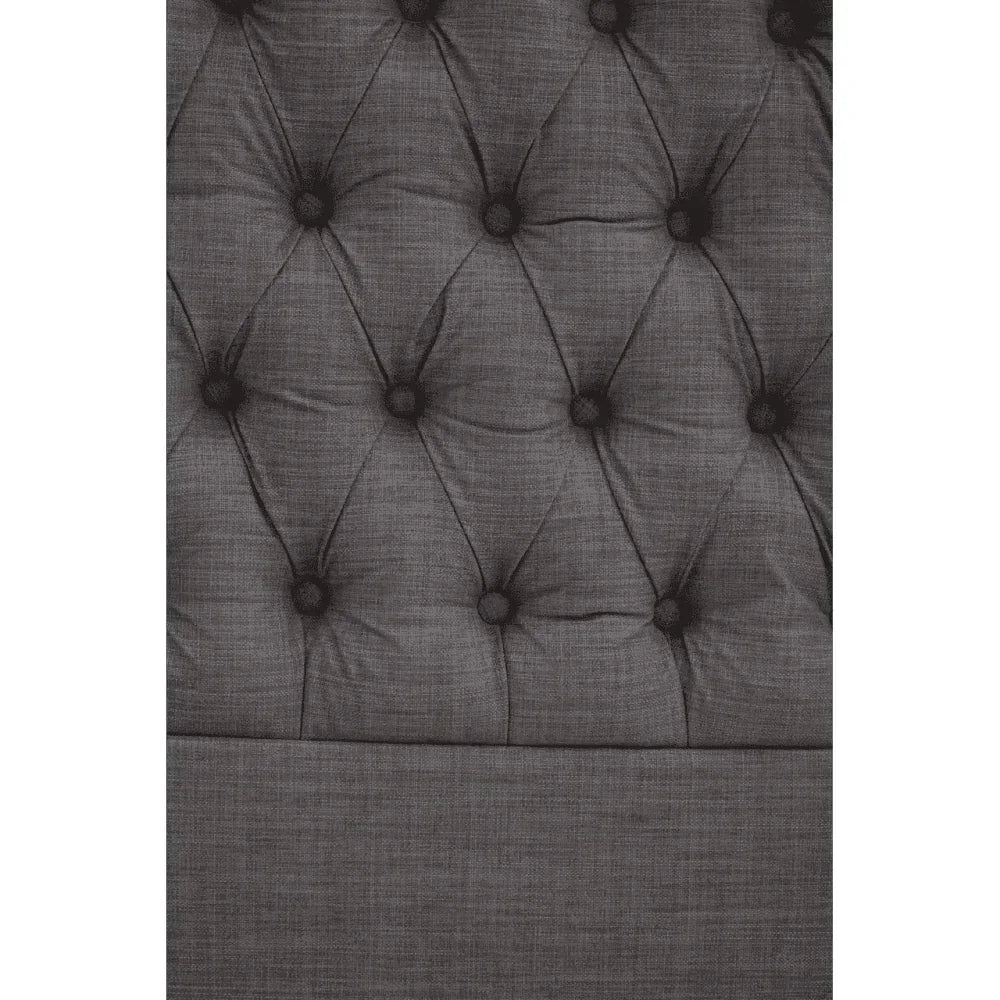 Dark grey upholstered headboard with button-tufted fabric detail, close-up view