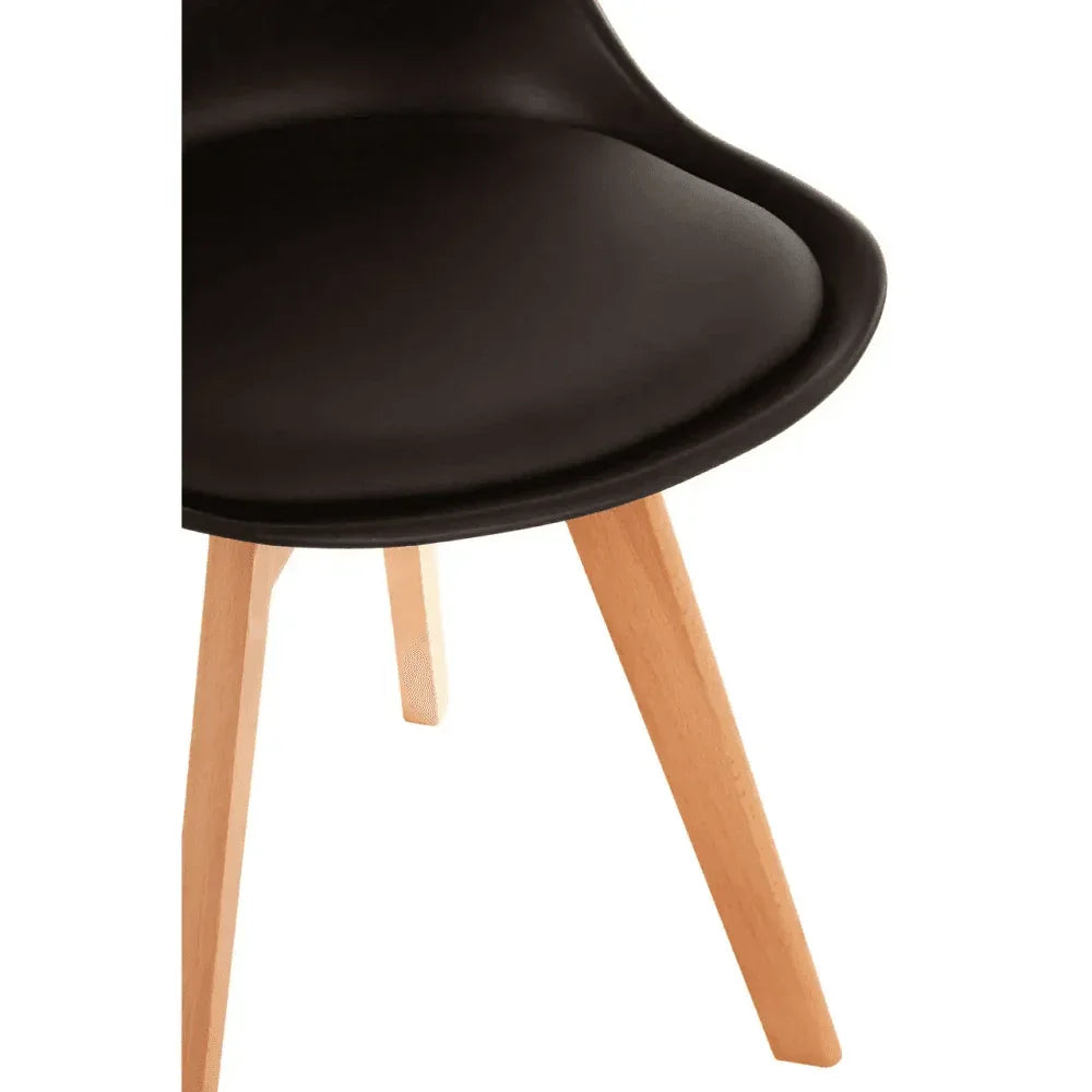 Closeup of black dining chair seat with light wooden legs